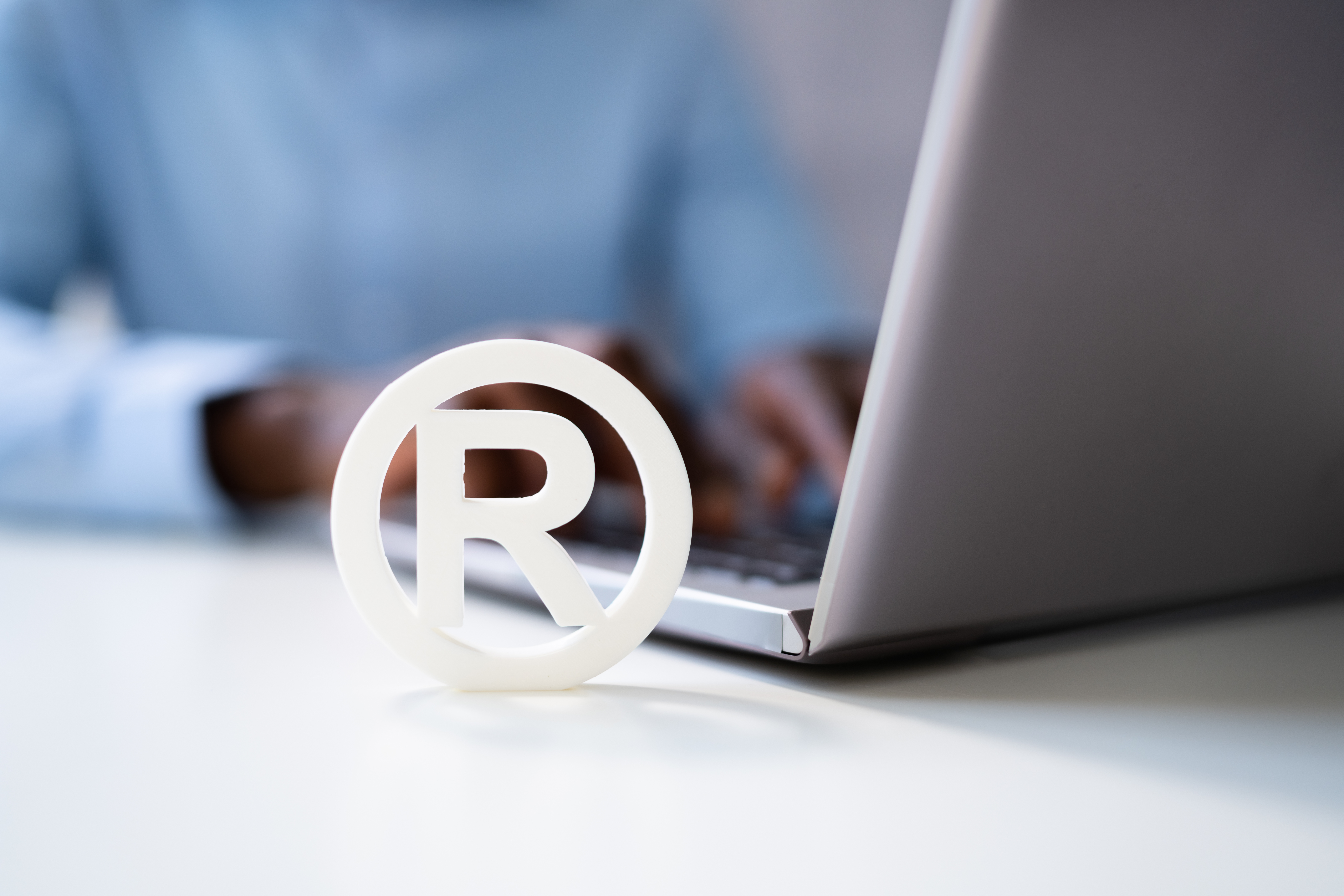 trabalhando no computador com um R do registro de marca em frente